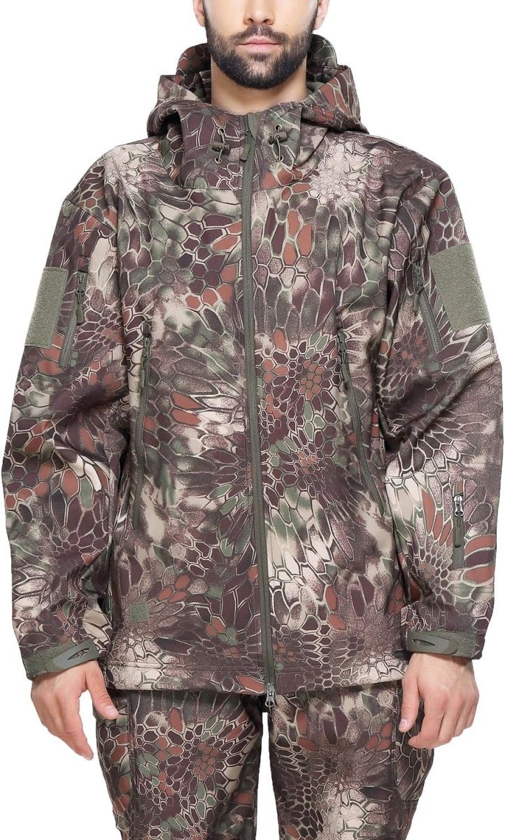 Load image into Gallery viewer, Man met een camouflage tactische heren softshell jas met capuchon, staande met de handen iets uitgestrekt, tegen een effen achtergrond.
