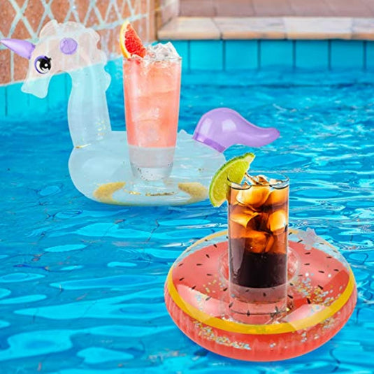 Twee koel je vloeistof en maak je feestje leuker in opblaasbare bekerhouders—een eenhoorn en een watermeloen schijf—naast een zwembad.
