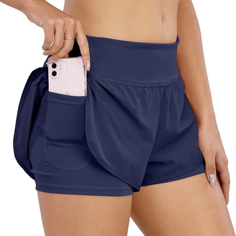 Load image into Gallery viewer, Vrouw die een smartphone toont, weggestopt in de zak van haar blauwe, vaste Sportbroek voor dames: comfortabel, krachtig en veelzijdig.
