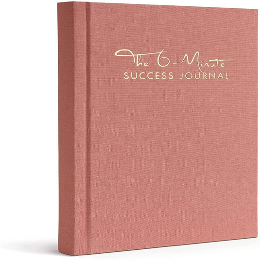 Een roze hardcover dagboek met de titel "Het 6-Minute Success Journal: Transformeer je Leven met Slechts 6 Minuten Per Dag!" gericht op productiviteit en mindfulness, tegen een witte achtergrond.