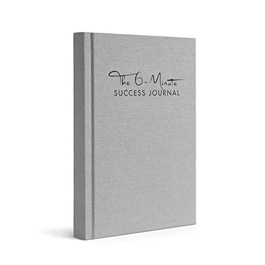 Een grijs hardcover boek met de titel "Het 6-Minute Success Journal: Transformeer je Leven met Slechts 6 Minuten Per Dag!" gericht op productiviteit en mindfulness, weergegeven in profielweergave.