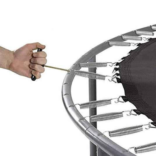 Een persoon houdt een trampoline vast waaraan een T-haak veertrekker is bevestigd.