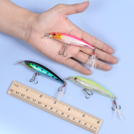Drie 3D-vissen en visaas: de ultieme manier om meer vis te vangen in een hand met een liniaal ernaast.
