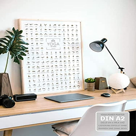 Een modern thuiskantoor met een grote manier om je yogapraktijk te verbeteren naast een bureau met een laptop, een bolvormige lamp en andere kleine spullen.